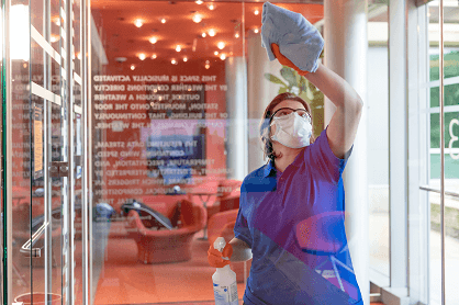 Conceptual - A photo of a custodian cleaning a window.